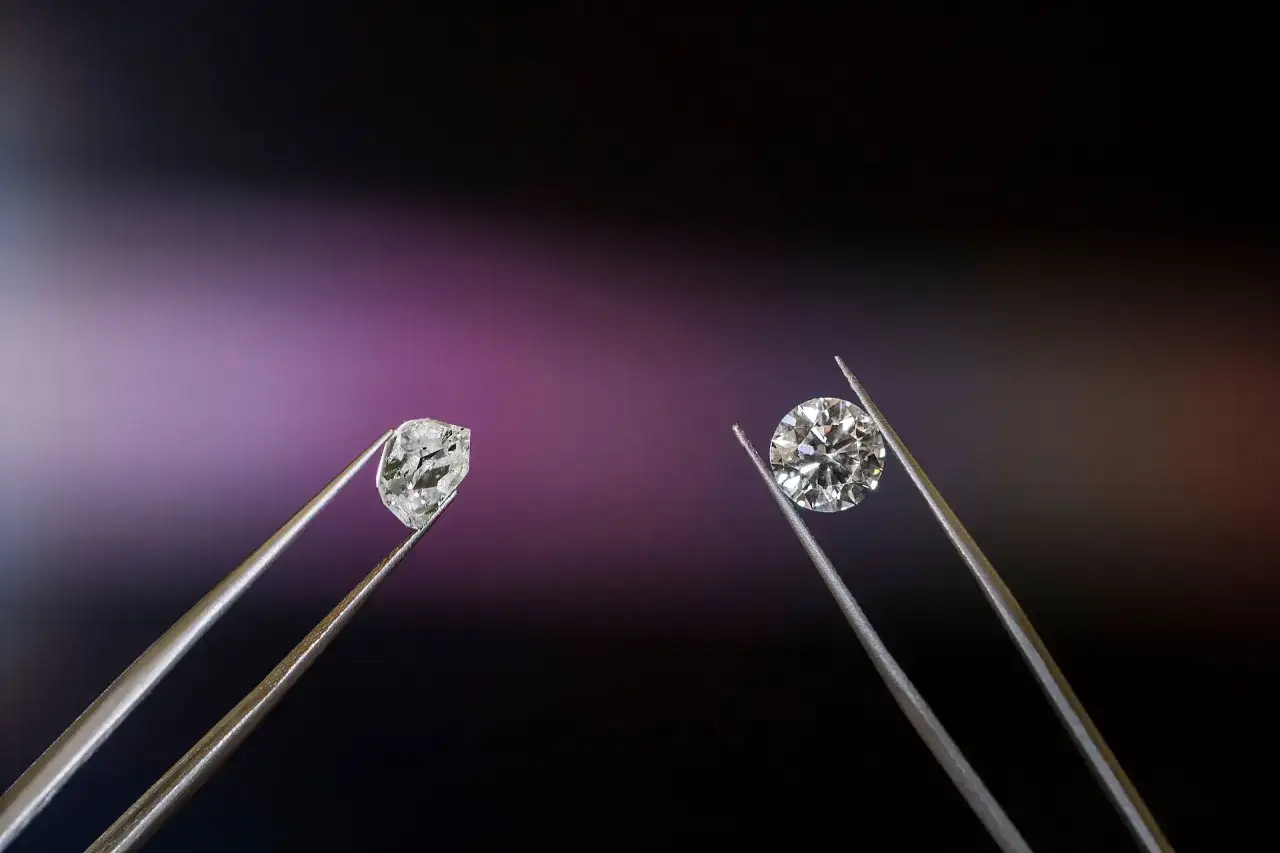 Dwa kamienie w pęsecie: surowy diament i oszlifowany brylant. Różnica w szlifie jest kluczowa, by zrozumieć, czym się różni diament od brylantu.